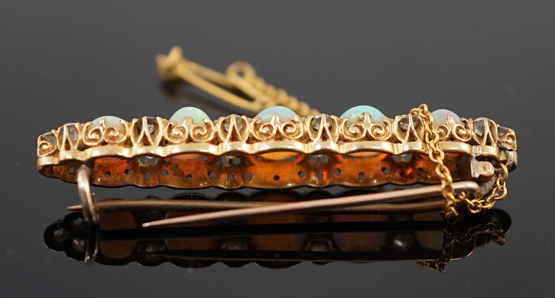 An early 20th century gold, diamond and oval white opal cluster set clip bar brooch